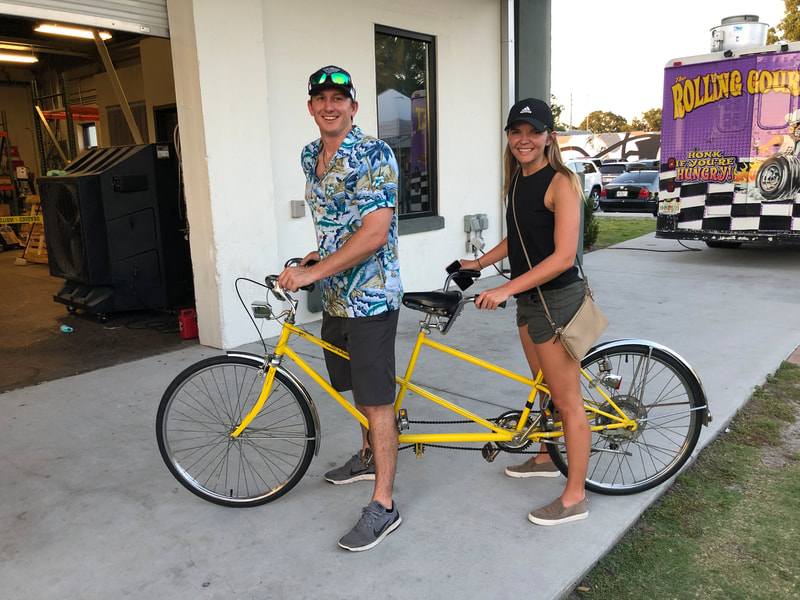 Couple riding a tandem bicycle in honor of the "Slow roll" event